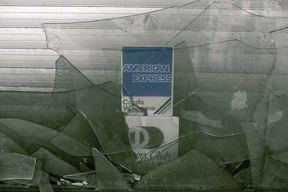photo d'une vitrine cassée sur laquelle étaient collés des autocollants Dinners Club et American Express, photo dominique houcmant aka goldo graphisme
