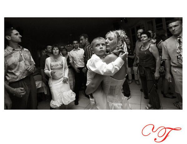 la mariée tient son enfant dans les bras sous l'objectif du photographe