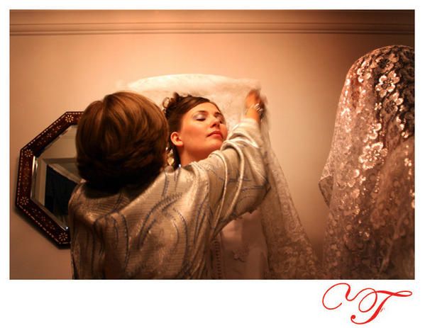la mariée est préparée avec sa robe de mariée devant l'appareil photo du photographe
