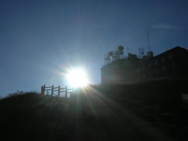 le soleil pointe derrière la station du sommet