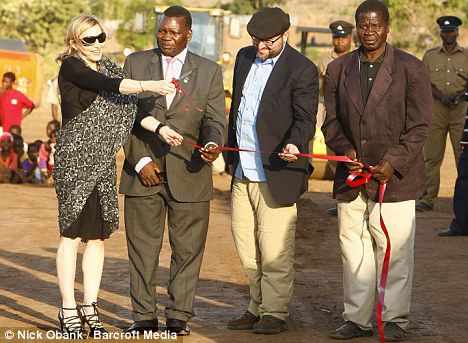 Despite the mud, Madonna still chose to wear delicate black heels as she cut the ribbon marking the beginning of construction