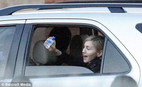 Madonna leaving Malawian orphanage waving a bottle of hand hygiene gel