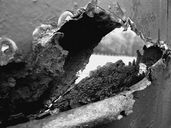 photo d'art image en noir et blanc, trou de rouille dans une porte en fer