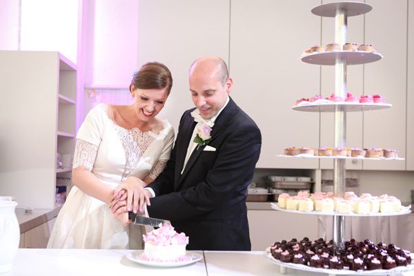 Hochzeitstorte anschneiden mit pralinen und Cupcakes
