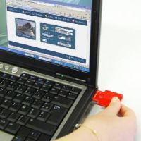Clé USB rouge insérée sur le côté d'un portable