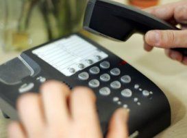 Personne en train de numéroter sur un téléphone fixe