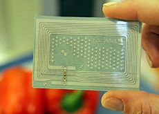 Tag RFID montré entre deux doigts