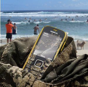 Nokia 3720 Classic jeté sur un sac dans le sable au bord d'une plage