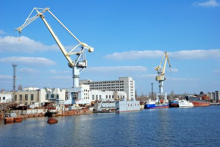 shipbuilding cranes and some sea ships near a pier