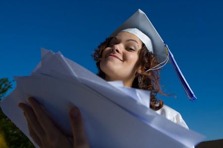 young graduate girl with heap of papers