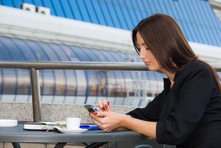 Business woman using palmtop outdoors