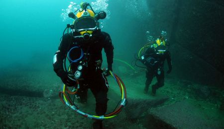 Navy divers assigned to the Chilean Buzo Salvatoaja, walk along the oc