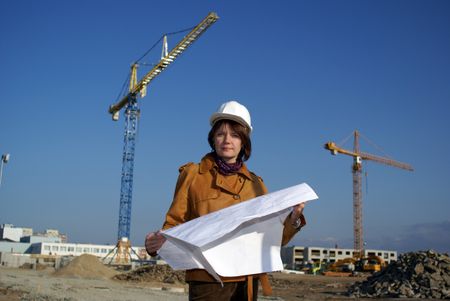 Pretty woman architect holding blueprints