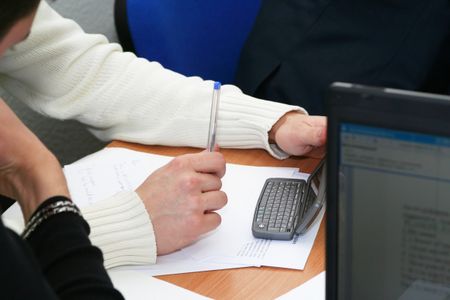 hand and pda on table at meeting