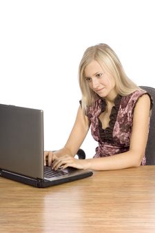 young blonde woman at the desk working laptop