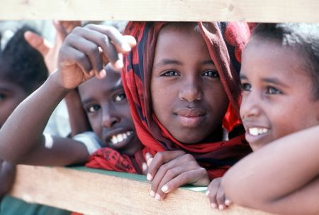 Somali children watch members of Naval Mobile Construction Battalion 1