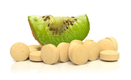 Slice of kiwi on a heap of tablets