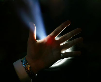 Man's hand on a background of a blue beam