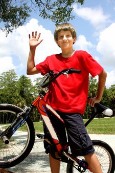 Teenager boy with bicycles in summer park