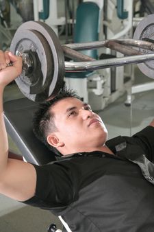 man lifting barbell in fitness center