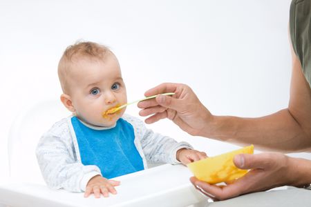 man feeding baby with a spoon, on bright background