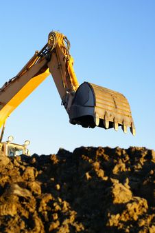 Hydraulic excavator at work. Shovel bucket against blue sky